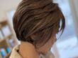 流れる前髪と明るめのアッシュブラウン白髪染めで仕上げた軽やかなショートボブ