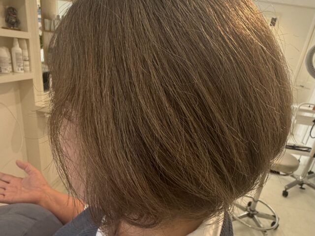 オリーブベージュの白髪染めで仕上げたボブの左側。ふんわりした丸みと内側にまとまる毛先