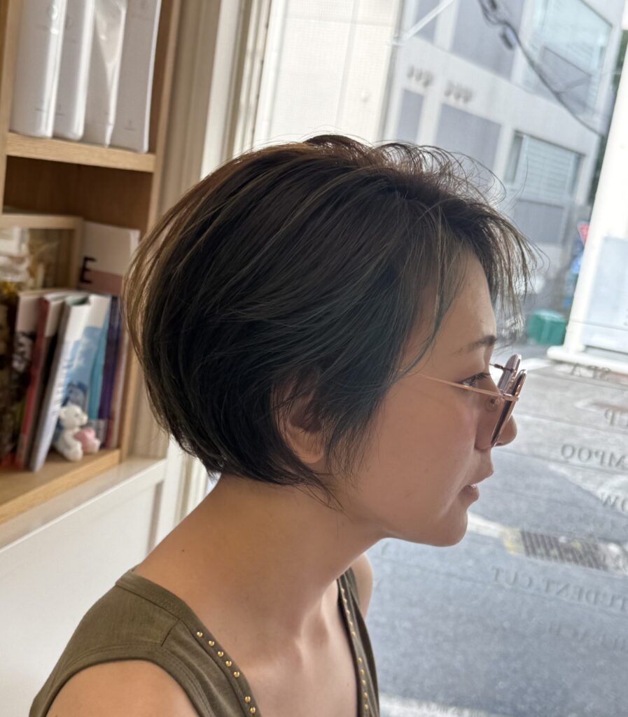 顔まわりのフェイスフレーミングとトップのハイライトを入れたオリーブベージュの前下がりショートボブ