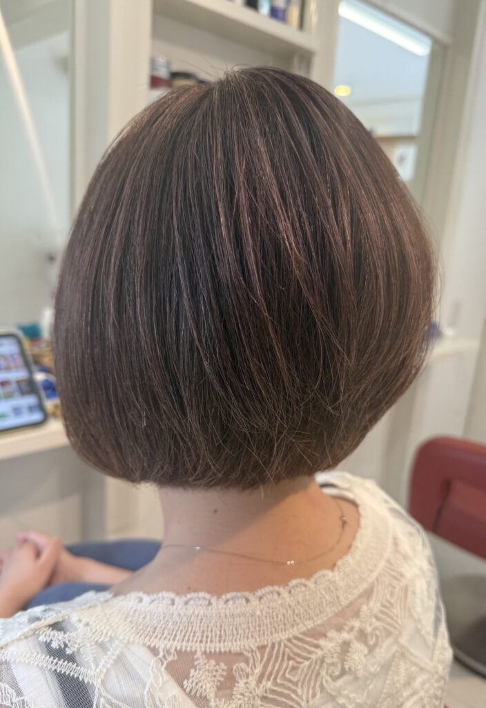 表面と顔まわりに控えめなレイヤーを入れた扱いやすいボブ