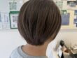 白髪をファッションカラーのミントグレージュで染めた丸みショートボブの後ろ姿