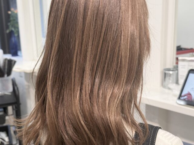 ブリーチなしのダブルカラーで明るいミルクティーベージュに仕上げた、毛先に緩やかな動きのあるロングヘア