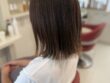 ショコラブラウンのボブを斜め後ろから見たスタイル。なめらかな毛流れと控えめに外へ向く毛先