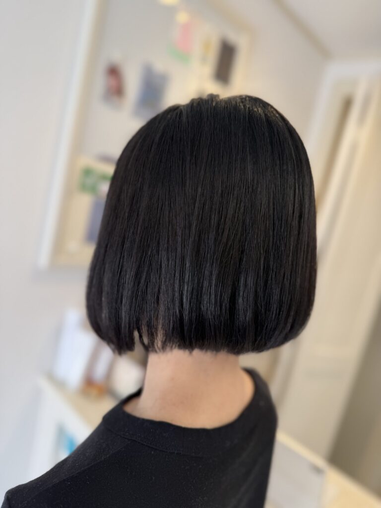 黒髪ボブの後ろ姿。自然な丸みと、首元でそろった厚みのある毛先のライン