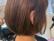 長い髪からカットした丸みボブの右斜め後ろ姿。ベージュ系カラーのやわらかな色合いと内側に収まる毛先
