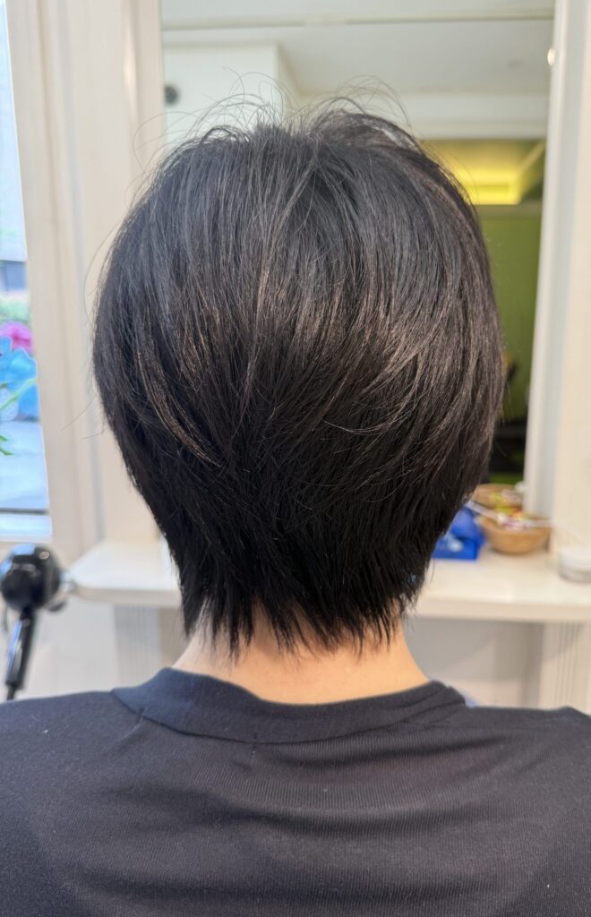 ショートレイヤーの後ろ姿。自然な毛流れと、後頭部から襟足へ細くなるシルエット
