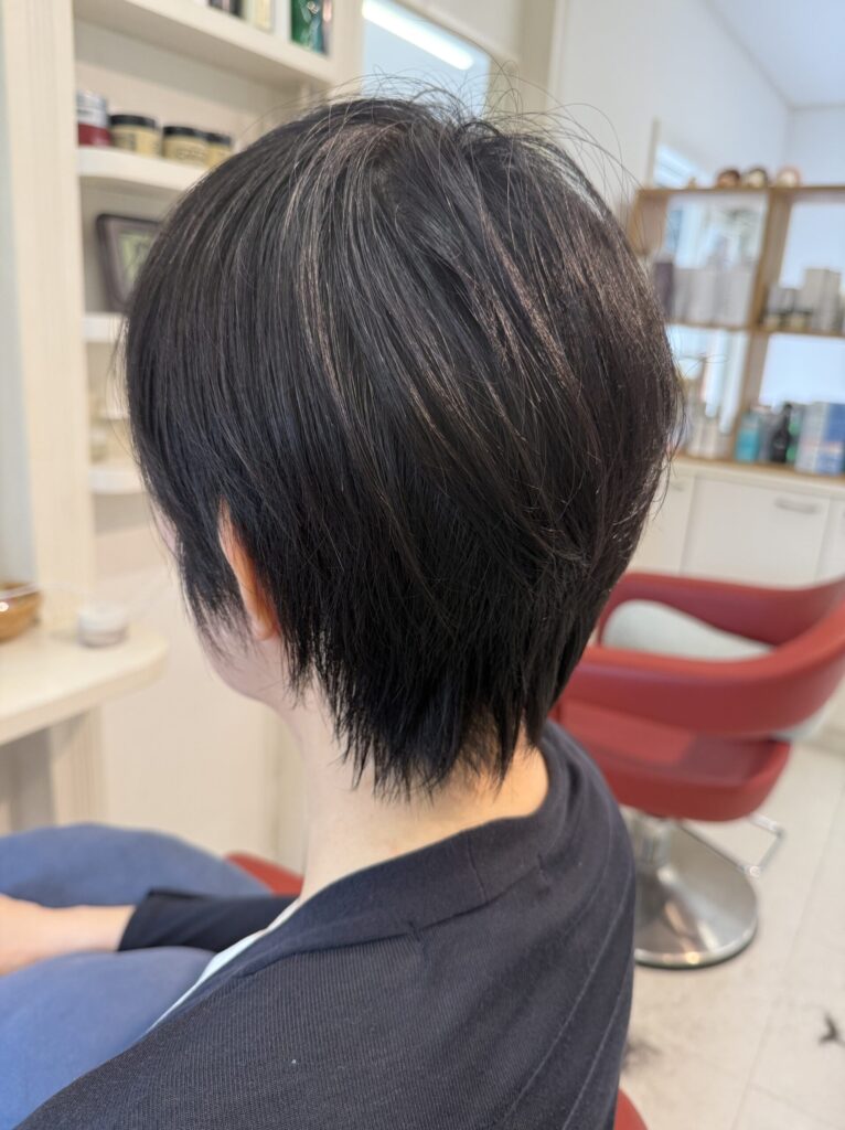 毛量と生えグセに合わせて整えたショートレイヤーの左斜め後ろ姿。後頭部の丸みとすっきりした襟足