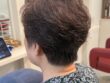 ファッションカラーで白髪を染めたショートヘア。後頭部の丸みとやわらかなパーマの毛流れ