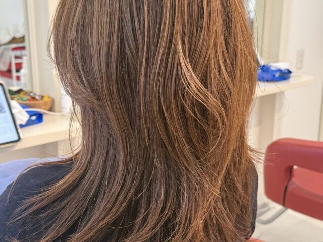収まりを考えてカットしたロングレイヤーの全体像。明るいアッシュオリーブ系ベージュとやわらかな毛流れ