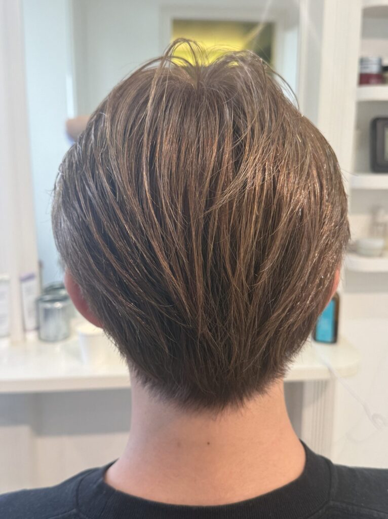 ブリーチなしのオリーブグレージュに仕上げたメンズヘアの後ろ姿。トップの動きとコンパクトな襟足
